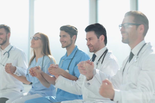 Foto felice gruppo di persone in camice bianco che si tengono per mano durante una teleconferenza