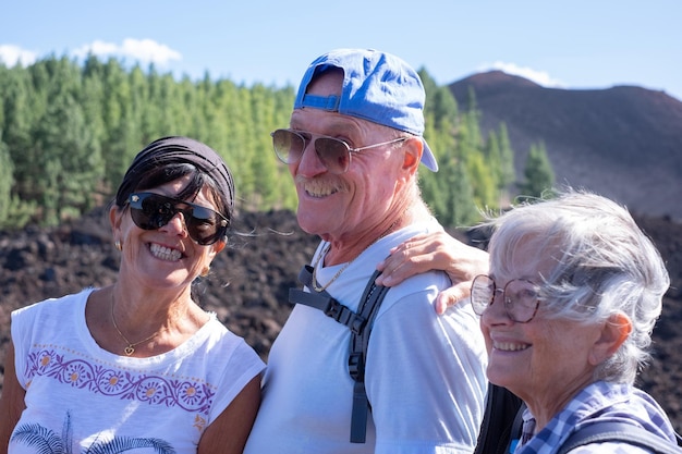 Happy group of senior people in mountain excursion smiling enjoying free time and freedom in nature