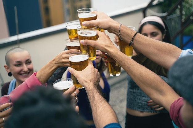 맥주와 함께 건배 하는 젊은 사람들의 행복 한 그룹입니다. 유스호스텔 테라스에서 다인종 학생들의 파티.