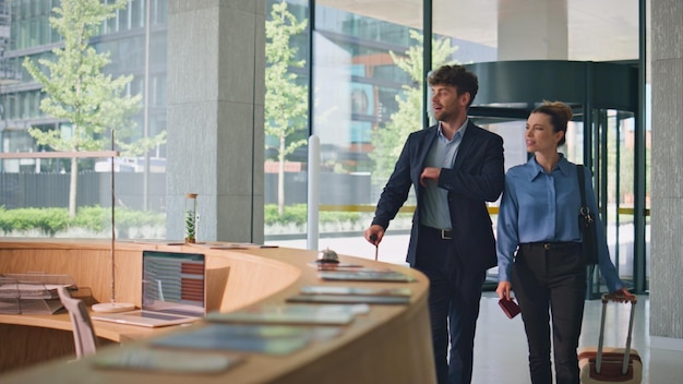 Happy guests arriving hotel carrying luggage late receptionist welcome couple