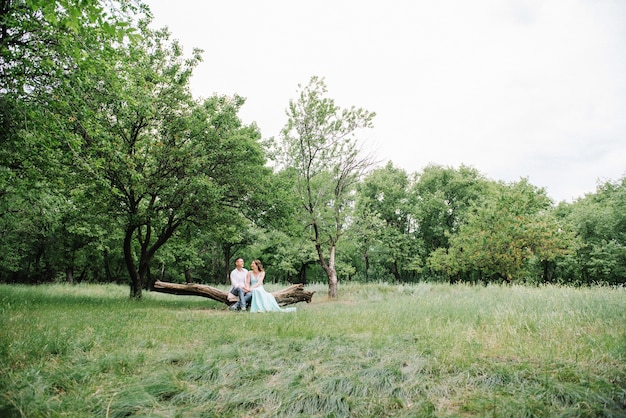 사진 흰 셔츠에 행복한 사람과 삼림 공원에서 산책하는 청록색 드레스에 여자