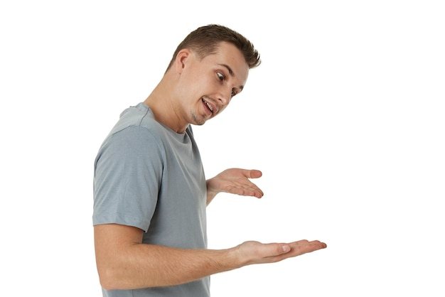 Happy guy pointing at the copy space on white studio background