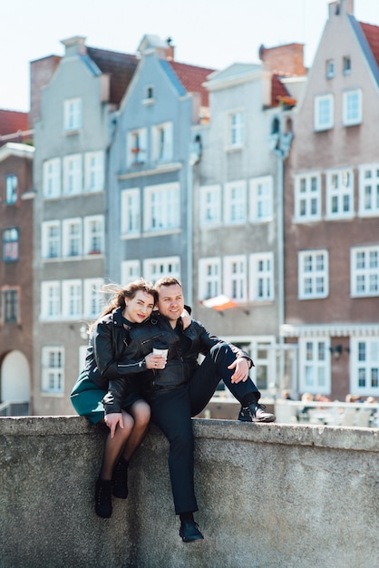 Happy guy and woman walking along the tourist streets of old Europe in the city of Gdansk