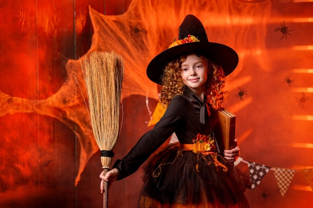 Happy Halloween Cute cheerful little witch with spell book and broom