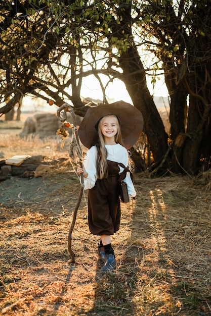 Happy Halloween. A cute girl in a witch costume is in the witch's den. Cute cheerful little witch brews a magic potion. Halloween.