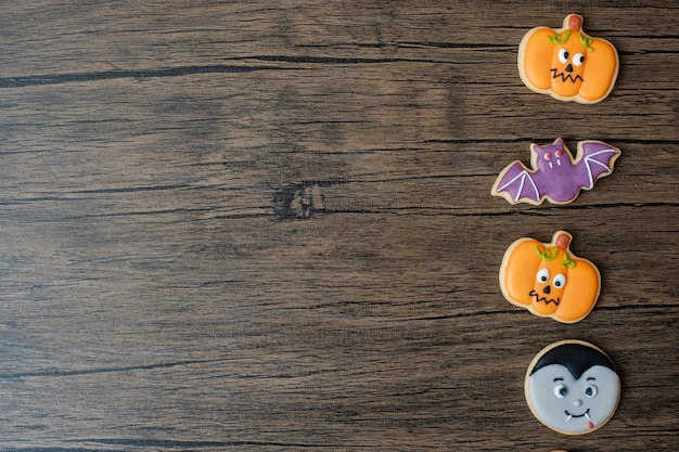 Foto felice giorno di halloween con biscotti divertenti messi sul fondo della tavola in legno. dolcetto o minaccia, ciao ottobre, autunno autunno, festivo, festa e concetto di vacanza