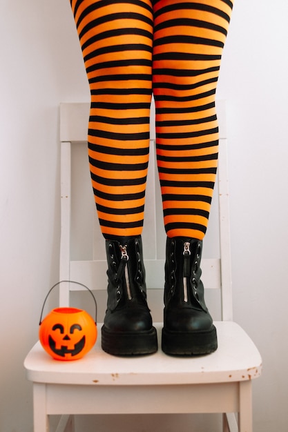 Photo happy halloween female feet in stockings with halloween decor