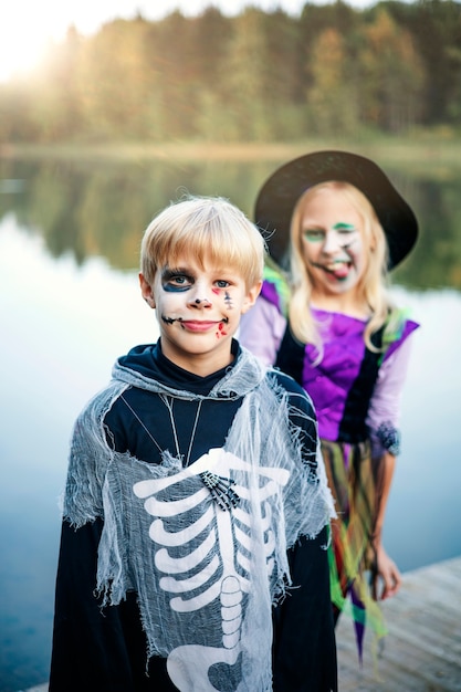 Foto felice halloween. bambini divertenti, fratello e sorella si divertono in costumi di carnevale al chiuso.