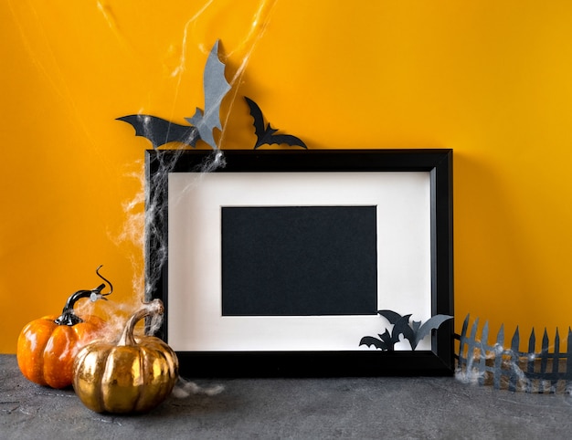Photo happy halloween holiday concept. halloween decorations, pumpkins, bats, black frame.