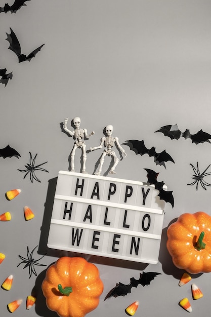 Happy halloween lightbox bord met pompoenvleermuizen en snoep op een grijze achtergrond