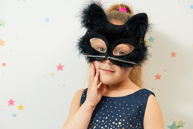 Happy Halloween . Little girl child in black cat mask, carnival costume. Funny face
