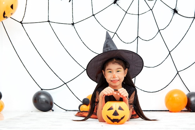 Happy Halloween little witch with a pumpkin