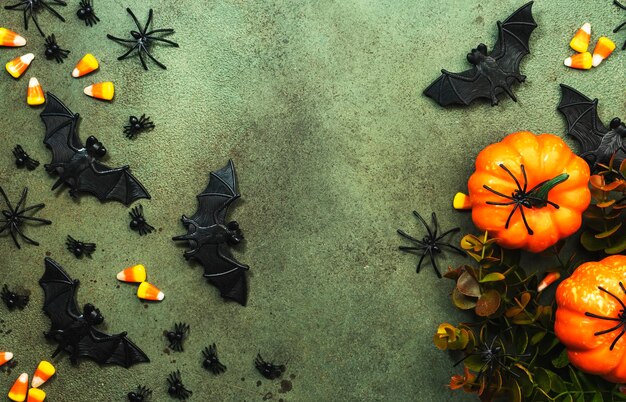 Happy halloween moeras groene achtergrond met pompoenen vleermuizen spinnen snoep maïs met kopie ruimte