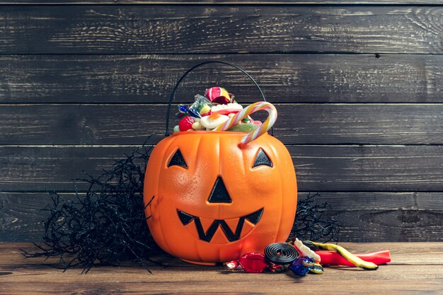 Happy halloween! Pumpkin with candy in the home.