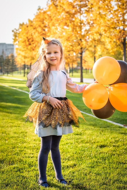 Happy Halloween Schattige kleine heks met een luchtbal jong kind meisje in heksenkostuum buitenshuis