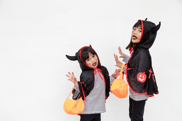 写真 ハッピーハロウィン！ハロウィーンの衣装と白い背景の上のカボチャの2人の子供