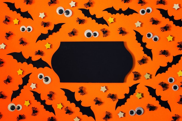 Happy Halloween-wenskaart met kleine decoratieve vleermuizen, spinnen en poppenogen.