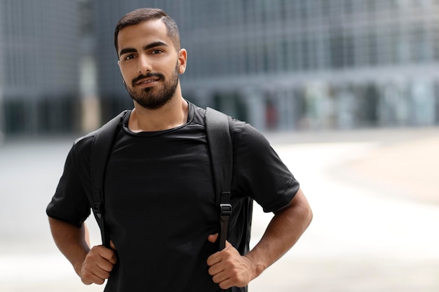 Happy handsome bearded student looking at camera and smiling