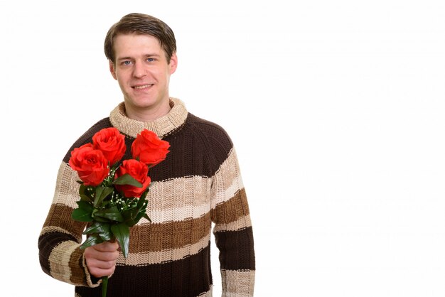 Счастливый красивый кавказский мужчина держит красные розы, готовые для Валенти