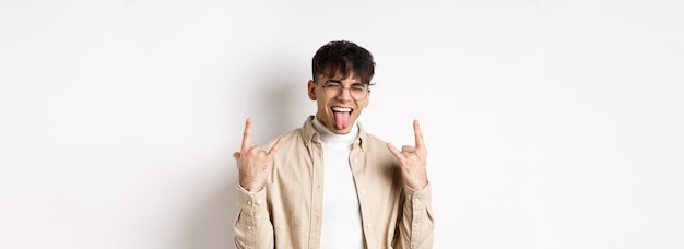 Happy handsome guy showing tongue and rockon gesture having fun and feeling upbeat enjoying somethin