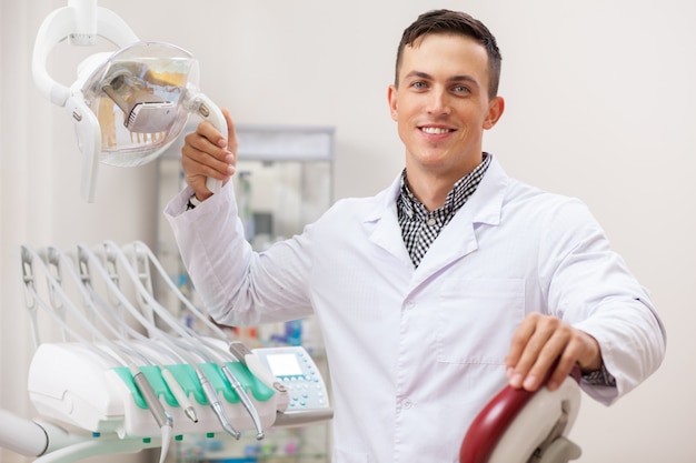 Happy handsome male dentist smiling joyfully,