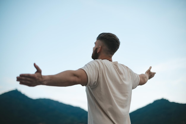 Happy handsome man relax nature young calm carefree man traveler with open raised hands enjoy