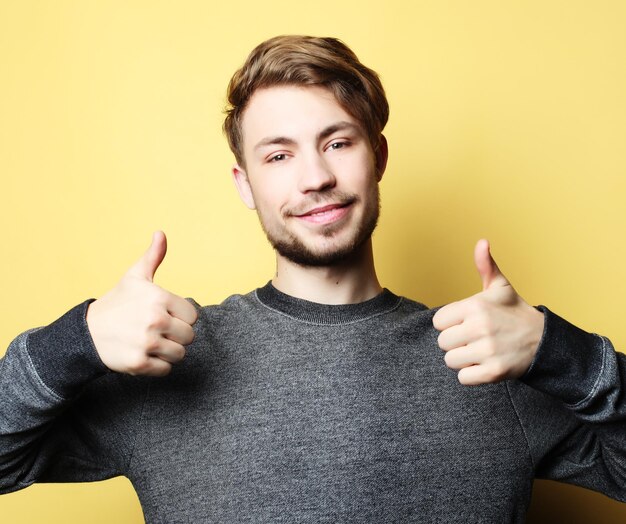 Foto uomo bello felice che mostra i pollici in su