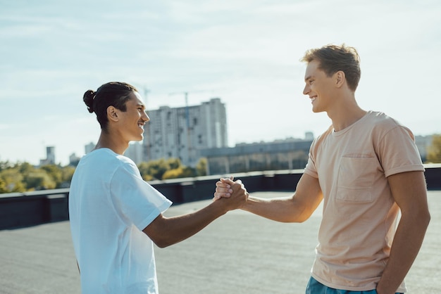 Uomini belli felici che si stringono la mano