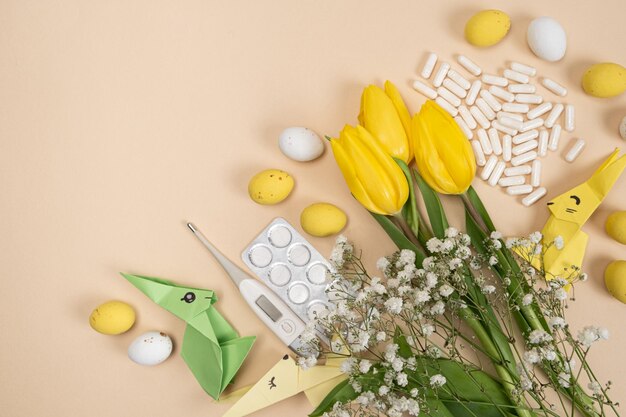 Happy and healthy Easter medical card with pills Easter bunny flowers and eggs place for text