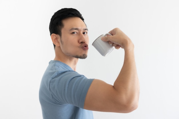 Happy healthy man drinks healthy coffee on isolated wall.