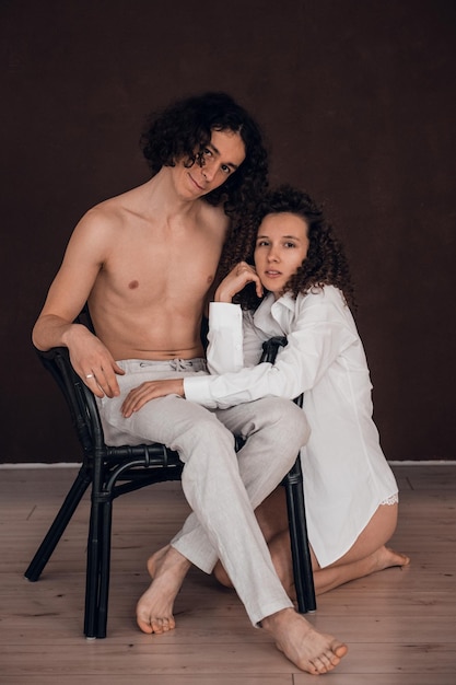 happy heterosexual couple man and woman embracing brown background