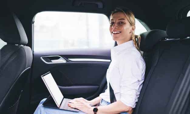 happy hipster girl looking at camera and smiling during online blogging via portable pc