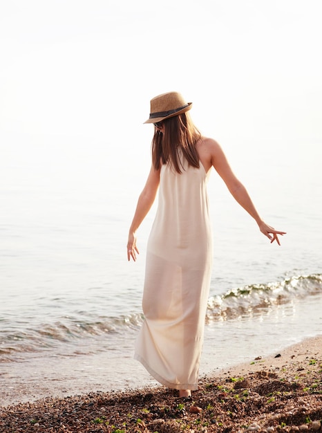 Happy hipster girl walking on a beach