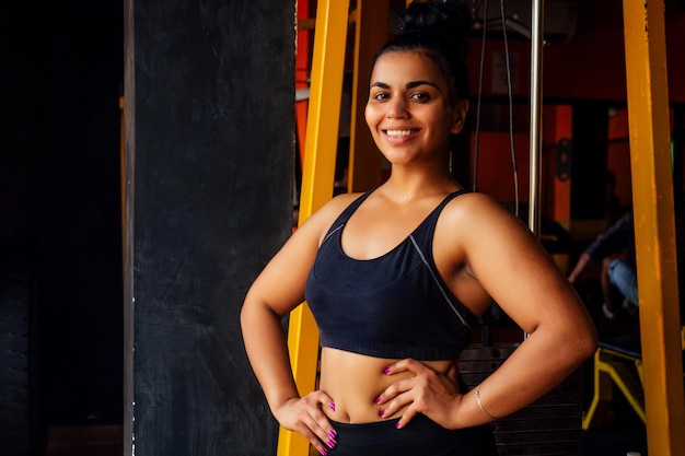 Happy hispanic latin american woman holding hands on the waist proudly looking at camera