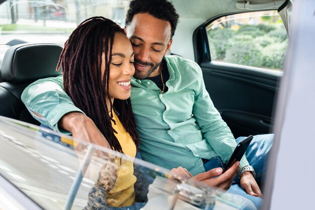 Happy hispanic latino couple driving in a taxi