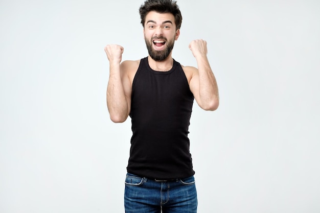 Happy hispanic man jumping from excitement out of frame