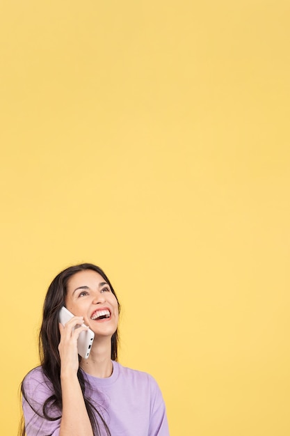 Happy hispanic woman smiling while talking to the mobile