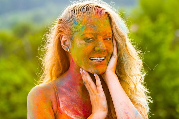 Happy Holi festival Laughing young woman with color powder on her face