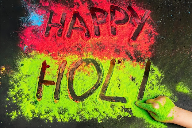 Happy holi inscription children's hand writes. .Holi background with colored powder