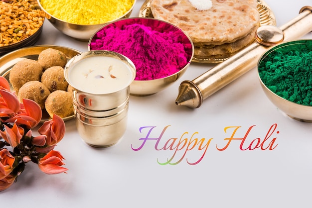 Happy Holi-wenskaart ontworpen met Indiase traditionele zoete en zoute gerechten, bloemen en poederkleuren gerangschikt op witte achtergrond of klei. Selectieve focus