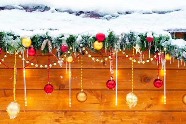 Foto concetto di buone feste decorazioni festive rami sempreverdi di natale coni palle sulla strada decorazione festiva della casa all'esterno in inverno