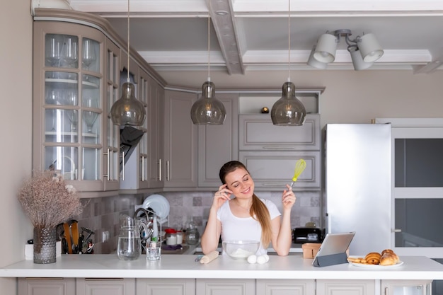 A happy housewife holding a whisk