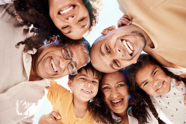 Happy huddle and portrait of a family in nature for bonding fun and playing in nature together Love support and parents grandparents and children hugging for vacation play and solidarity