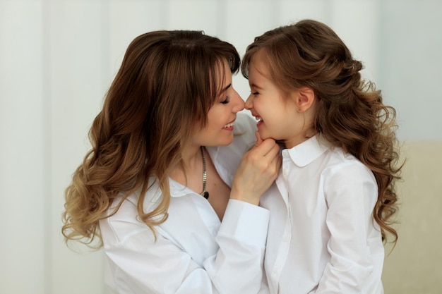 Happy hugs of a beautiful mother and her affectionate daughters