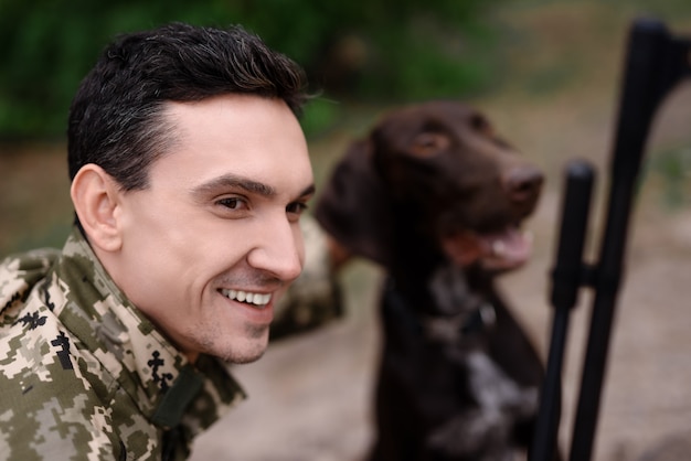 Foto happy hunter in camouflage huisdierenvriendelijke hond.