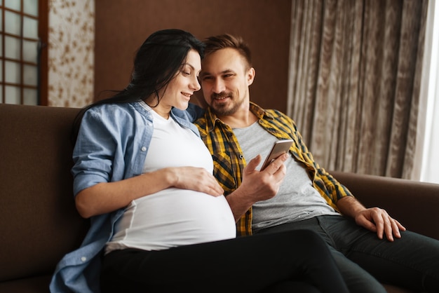 Happy husband touching the belly of his pregnant wife. Pregnancy, prenatal period. Expectant mom and dad are resting