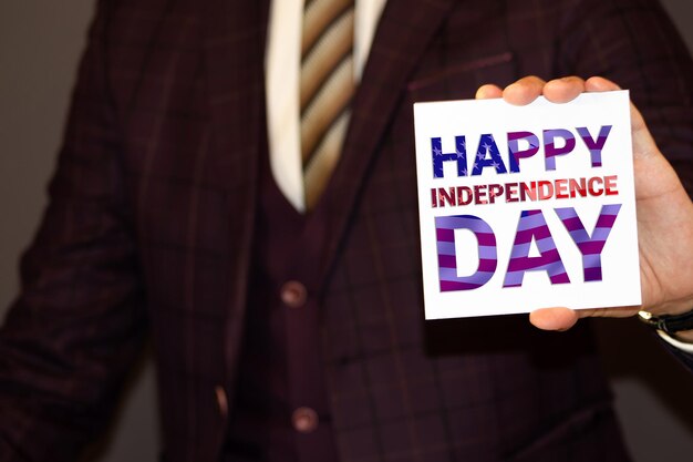 HAPPY INDEPENDENCE DAY inscription in the hands of a young man