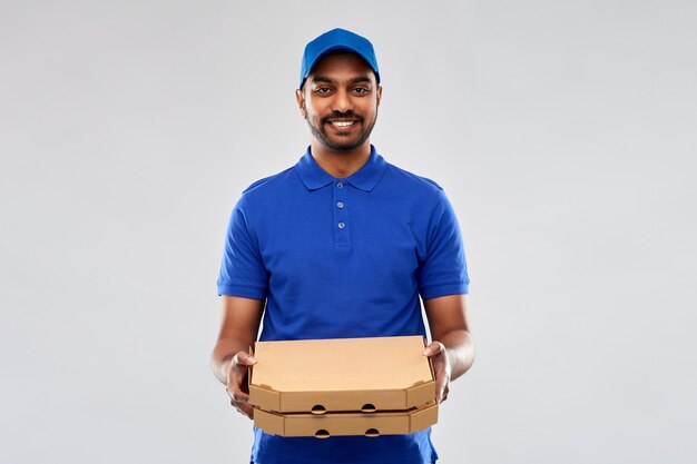 happy indian delivery man with pizza boxes in blue