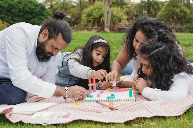 Happy indian family enjoy day together at city park Hindu parents having playful time with children outdoor