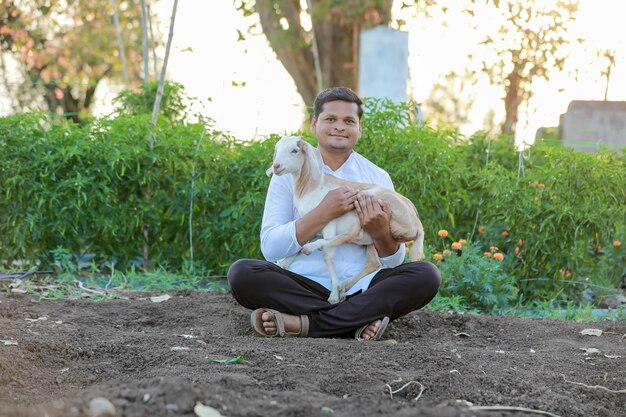 Happy indian farmer holding indian goat